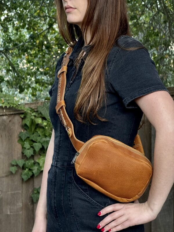 A woman wearing a brown leather purse.