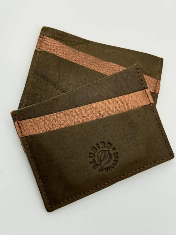 Two brown leather wallets sitting on top of a table.