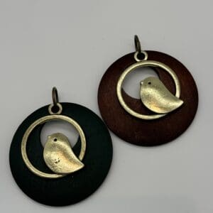 A pair of bird earrings sitting next to each other.
