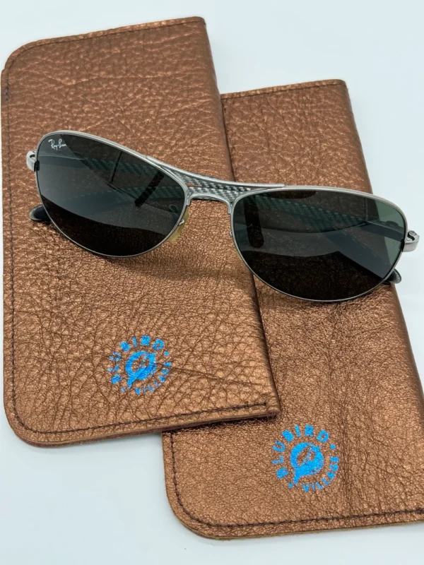 A pair of sunglasses sitting on top of a brown case.