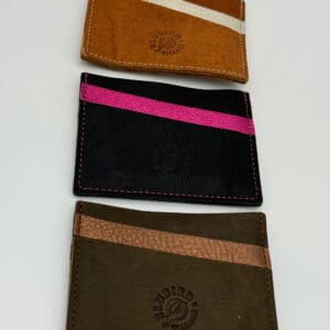Three different colored wallets are shown on a table.