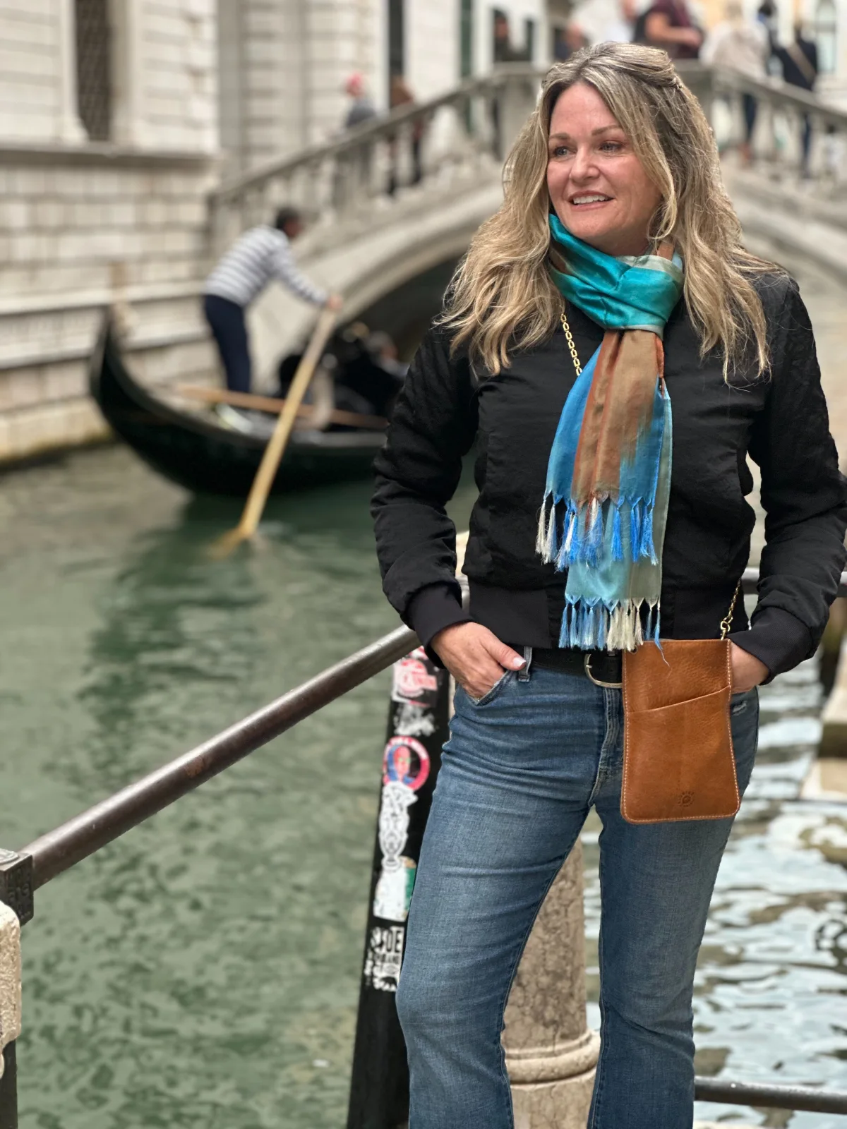 A woman standing on the side of a canal.