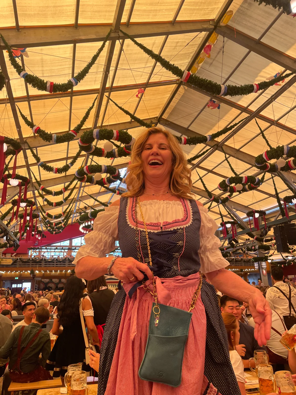 A woman in a dirndl is standing under a tent.